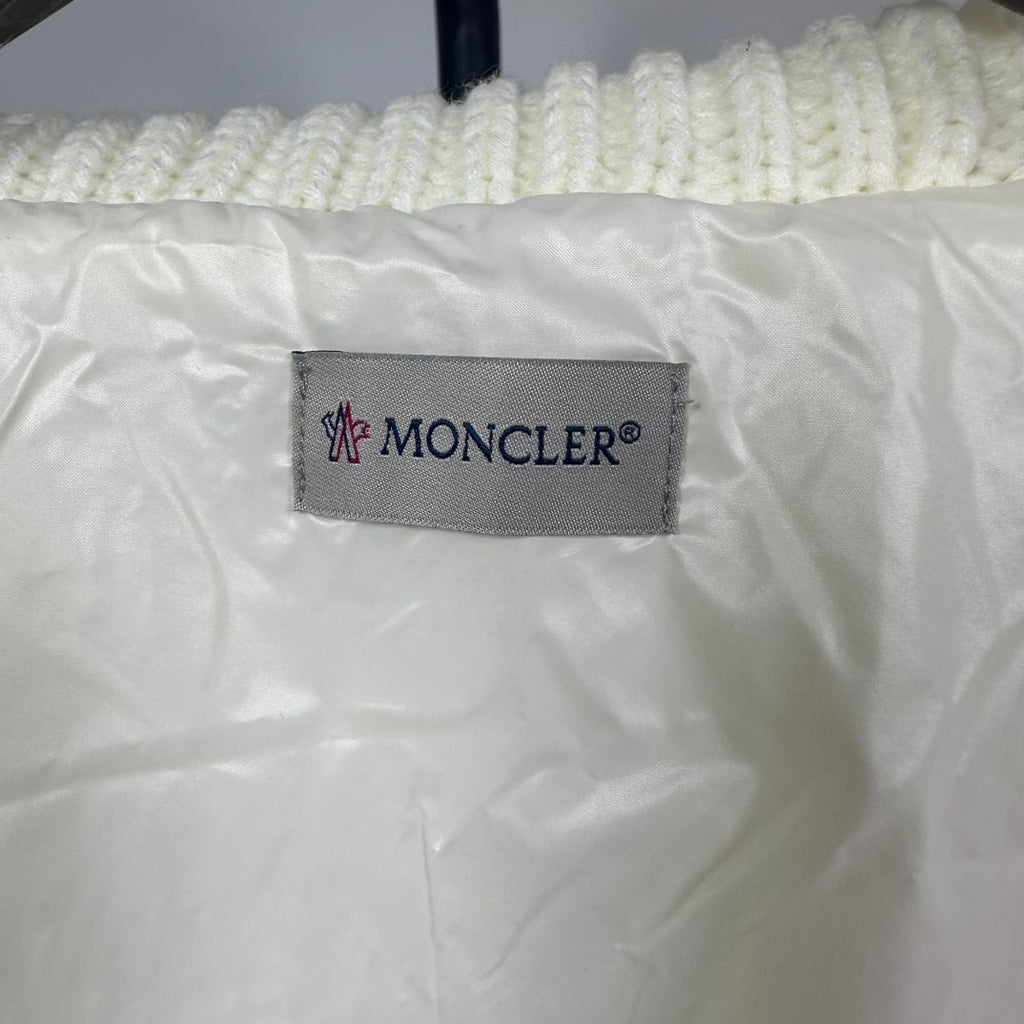 Long puffer jacket interior brand label: Moncler tag on off-white fabric