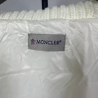 Long puffer jacket interior brand label: Moncler tag on off-white fabric