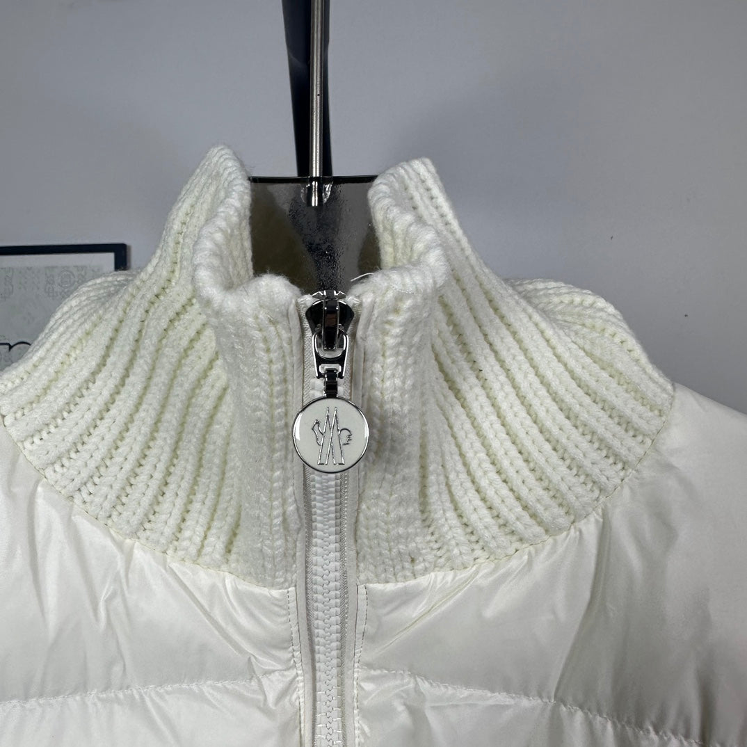 Long puffer jacket front close-up with off-white ribbed collar and zipper pull