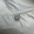Long puffer jacket size tag on off-white fabric