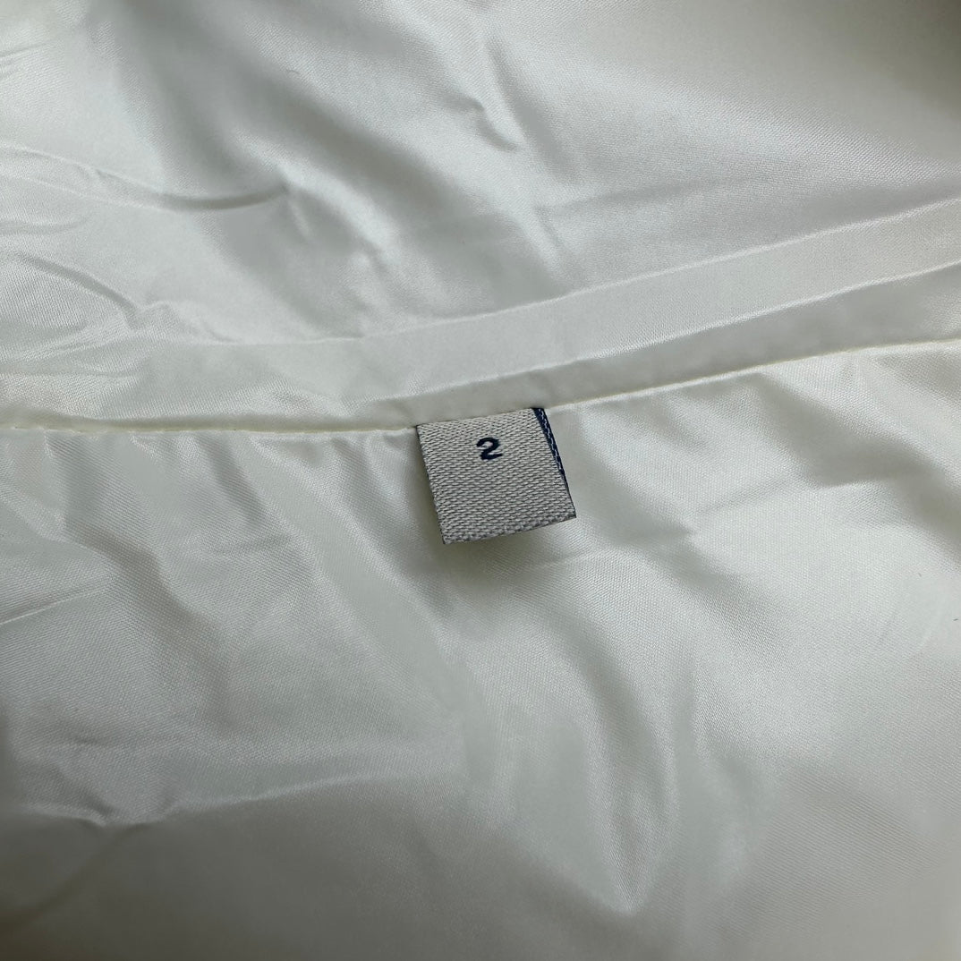 Long puffer jacket size tag on off-white fabric