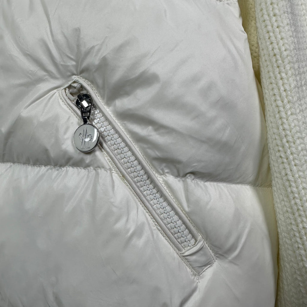 Long puffer jacket sleeve detail: off-white zipper pull and textured fabric