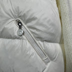 Long puffer jacket sleeve detail: off-white zipper pull and textured fabric