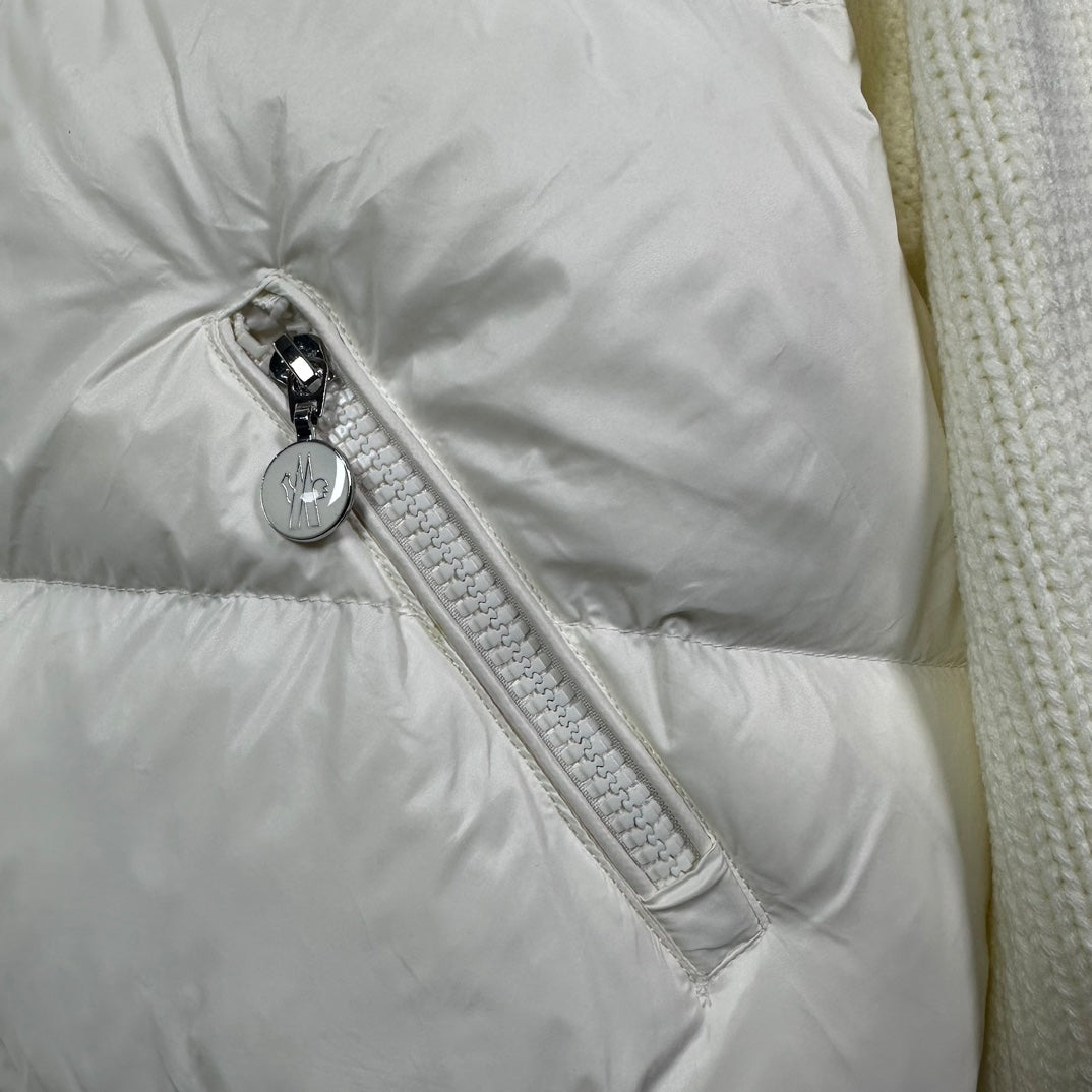 Long puffer jacket sleeve detail: off-white zipper pull and textured fabric