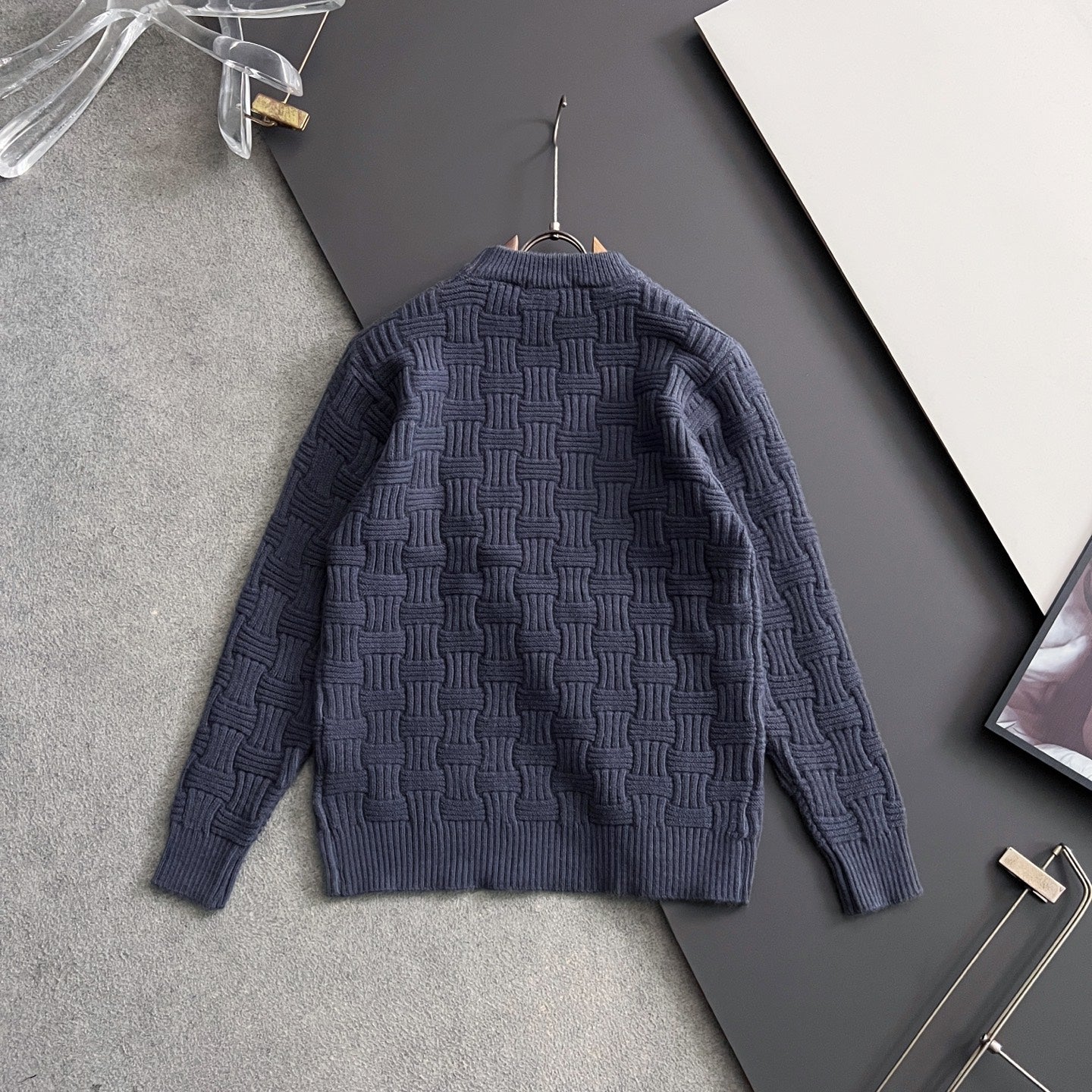 Dark blue textured knit sweater back view on hanger
