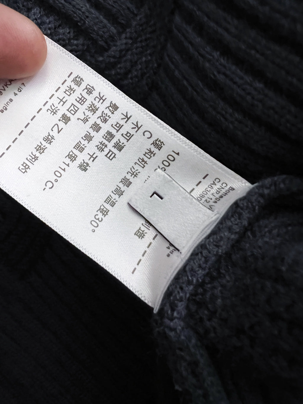 White care label on dark blue knit sweater