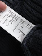 White care label on dark blue knit sweater