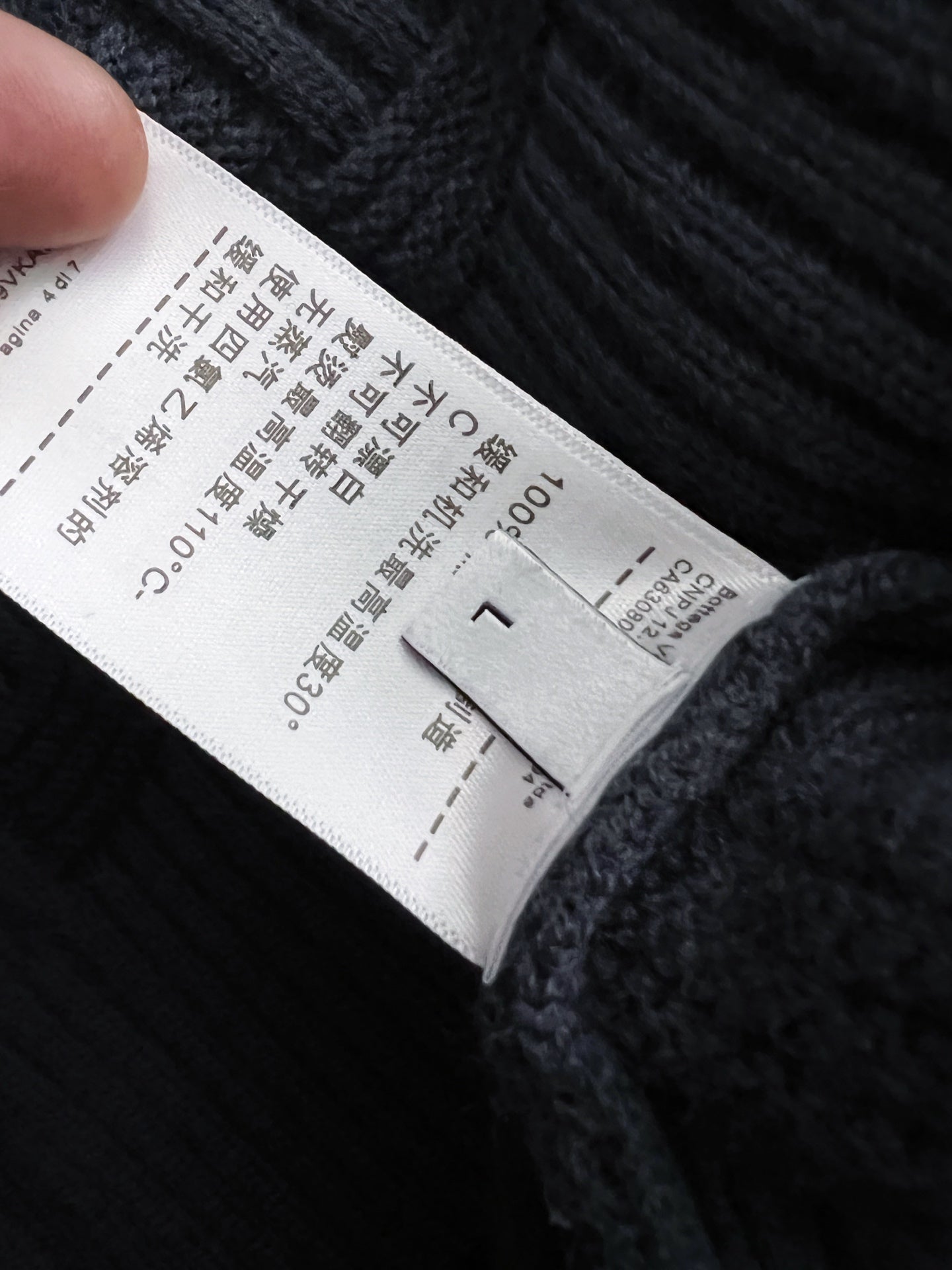 White care label on dark blue knit sweater