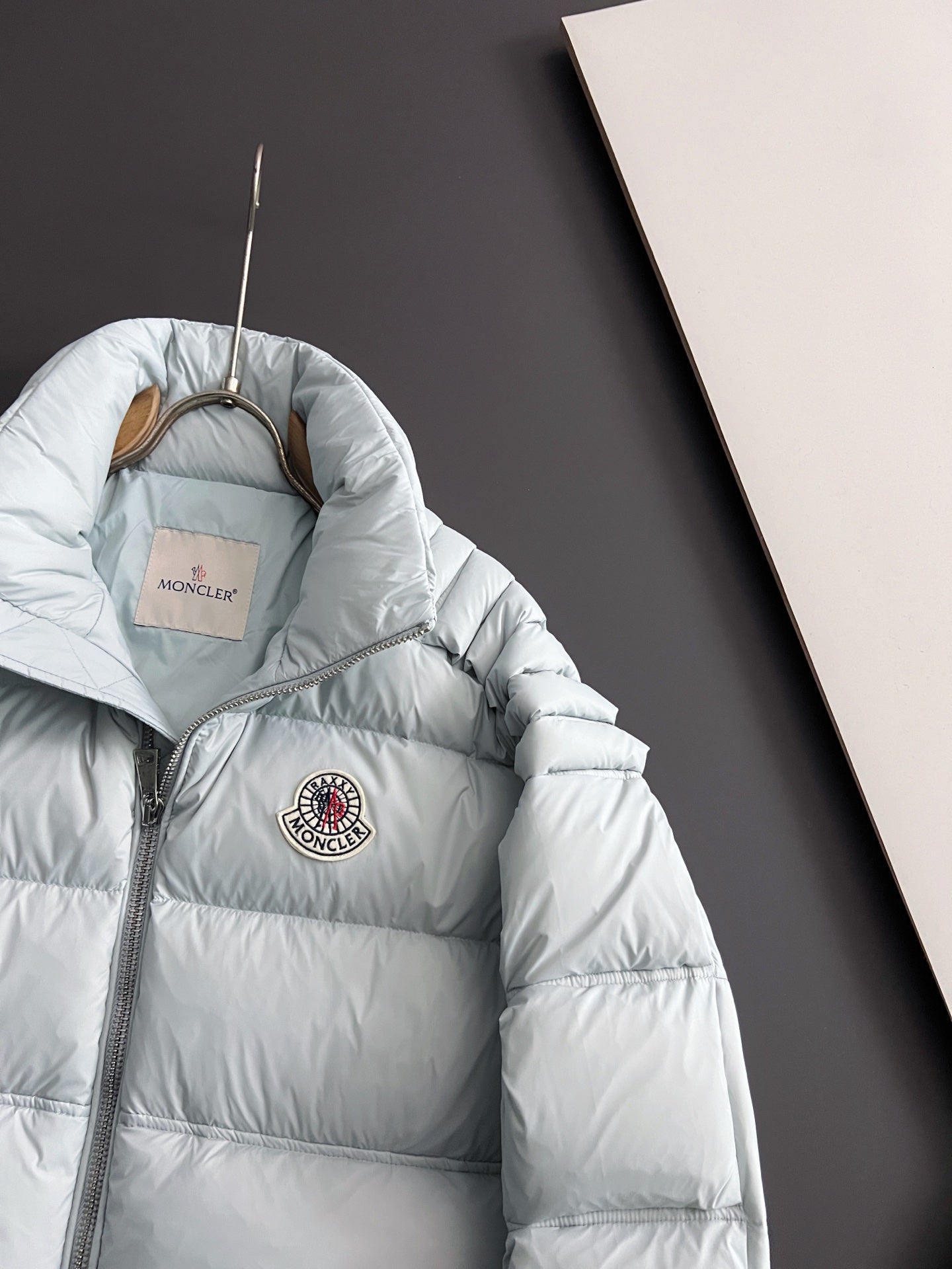 Moncler light puffer jacket with hood and round chest logo patch, side view