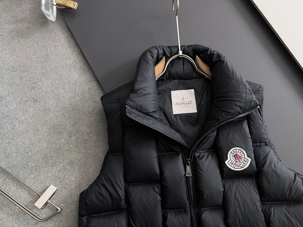 Black long Moncler puffer jacket with hood and crest patch on sleeve