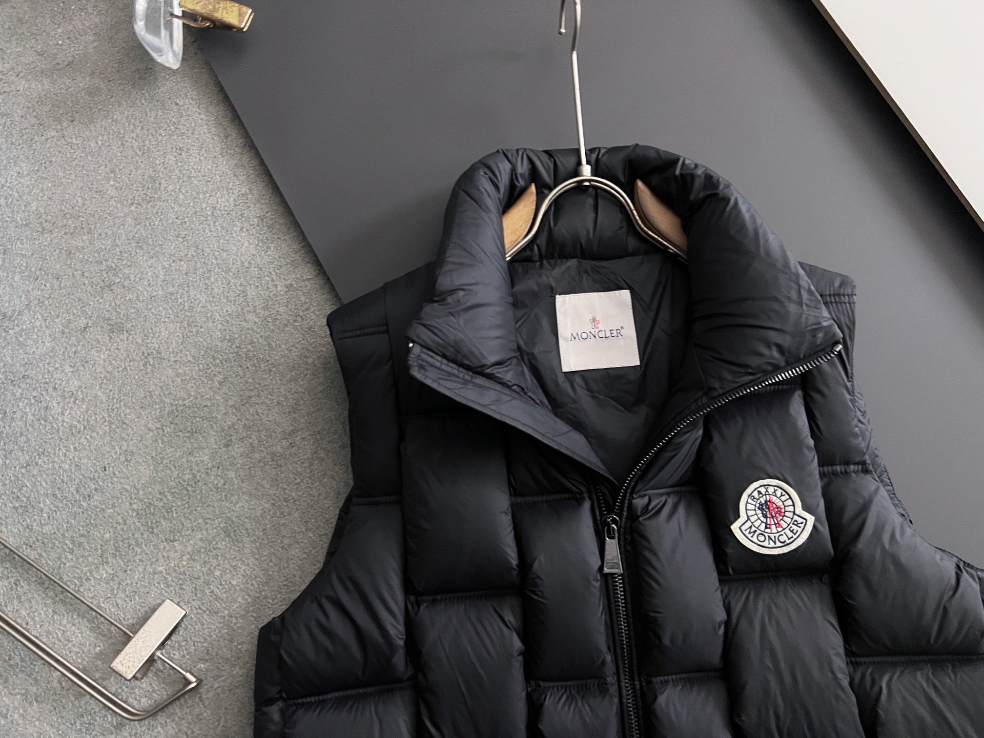 Black long Moncler puffer jacket with hood and crest patch on sleeve