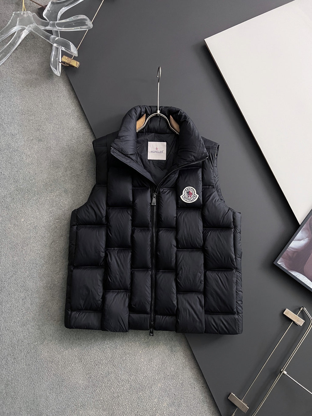 Black long puffer jacket with stand collar, front zipper, and hood tag