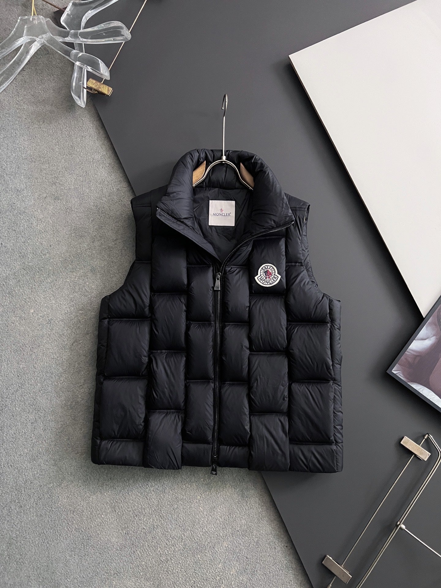 Black long puffer jacket with stand collar, front zipper, and hood tag
