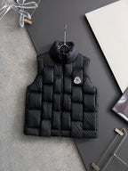 Black long puffer jacket with full zipper, hood, and side logo patch