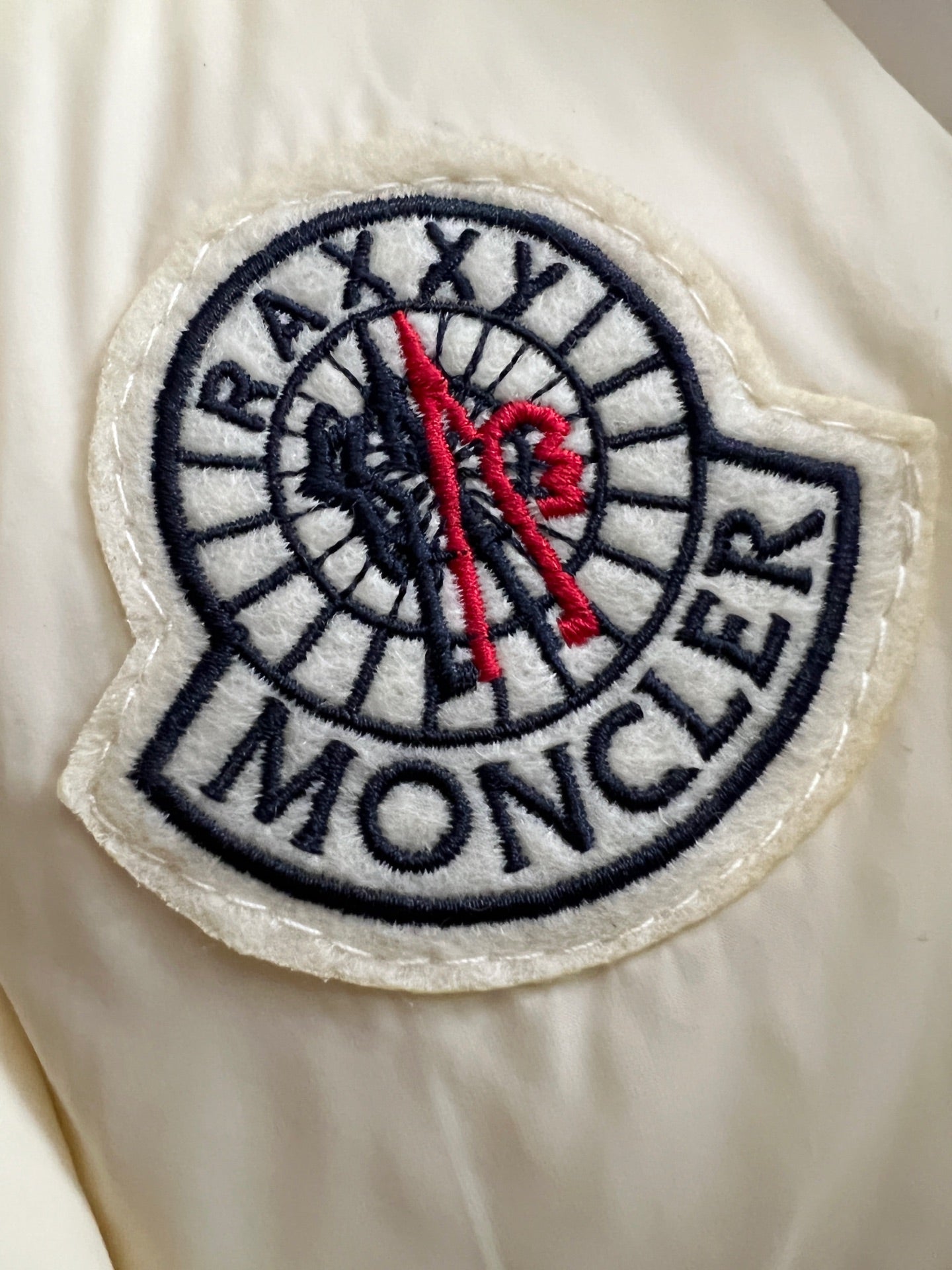 Moncler circular logo patch on cream puffer jacket