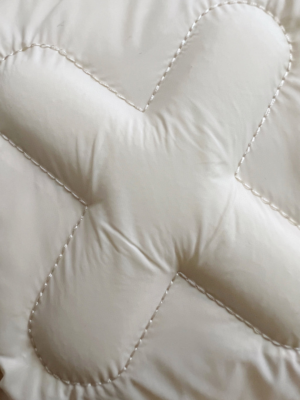 Cream puffer jacket fabric with stitched quilted panels and padding lines