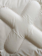 Cream puffer jacket fabric with stitched quilted panels and padding lines