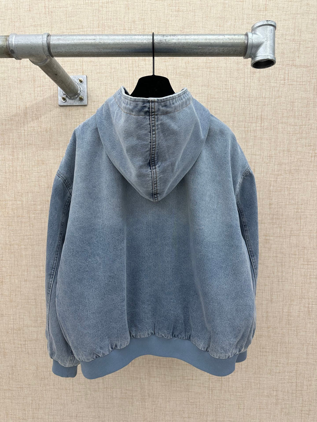 Light blue denim zip-up hoodie jacket with hood and logo print, back view