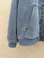 Light blue denim jacket front pocket panel with snap closure and ribbed cuff