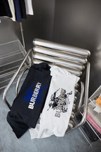 Burberry navy hoodie and white T-shirt on hangers; navy has blue logo