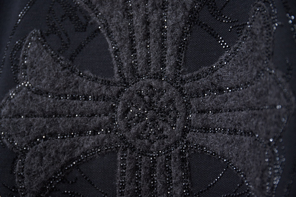 Close-up of black rhinestone graphic detailing on sweatshirt
