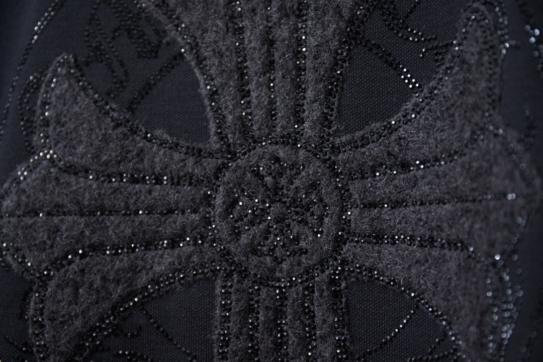Close-up of black rhinestone graphic detailing on sweatshirt
