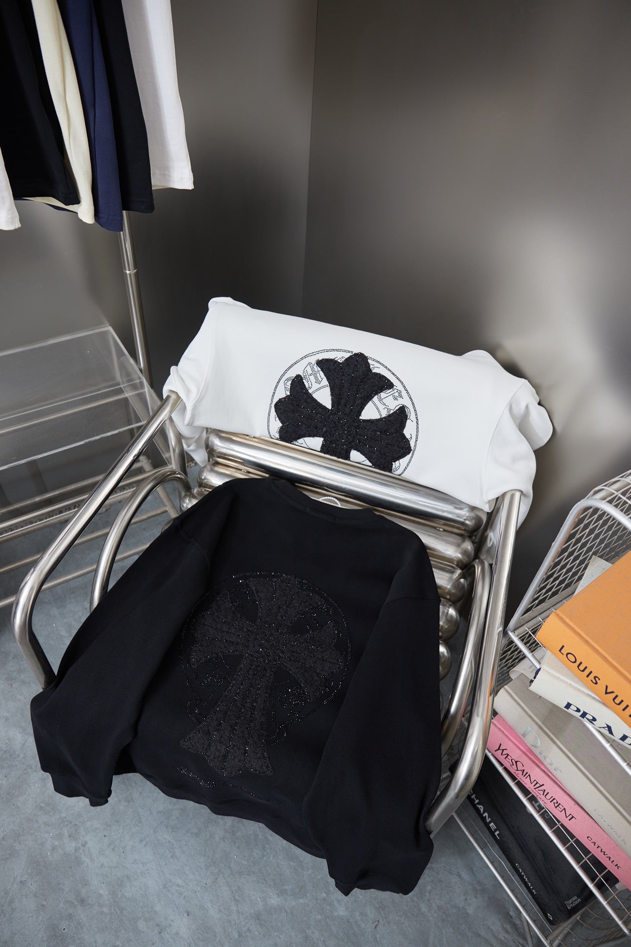 Black and white crewneck sweatshirts with circular rhinestone emblem, folded