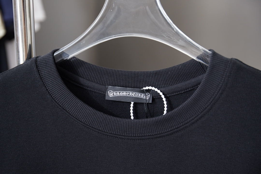 Black crewneck sweatshirt neckline with ribbed collar and woven tag