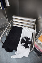 Folded black and white crewneck sweatshirts with rhinestone logo on display