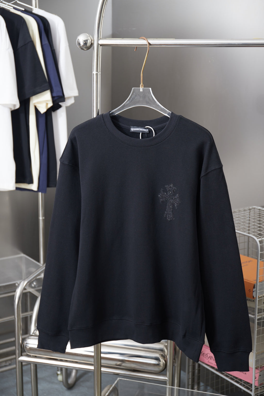 Black long-sleeve crewneck sweatshirt with small rhinestone logo on chest