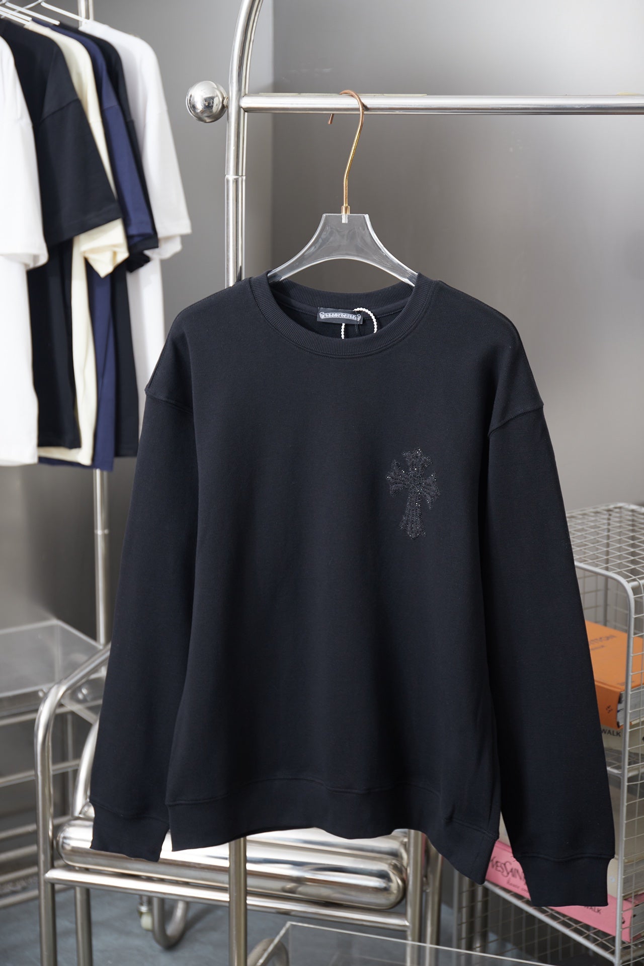 Black long-sleeve crewneck sweatshirt with small rhinestone logo on chest