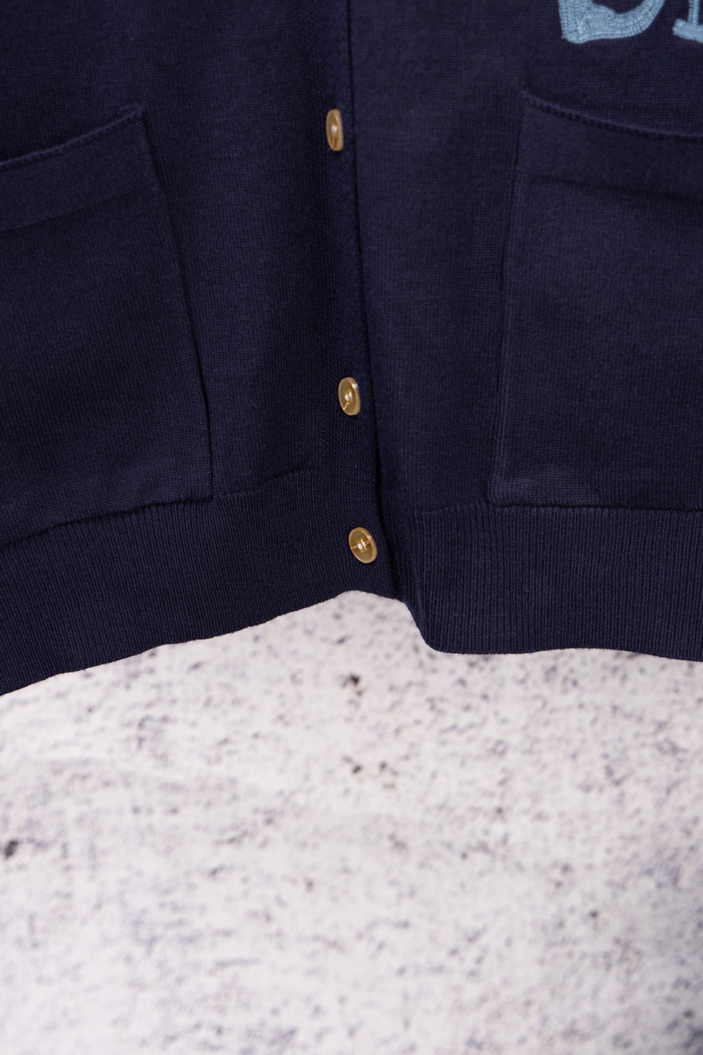 Navy cardigan front placket with gold button row and side pockets