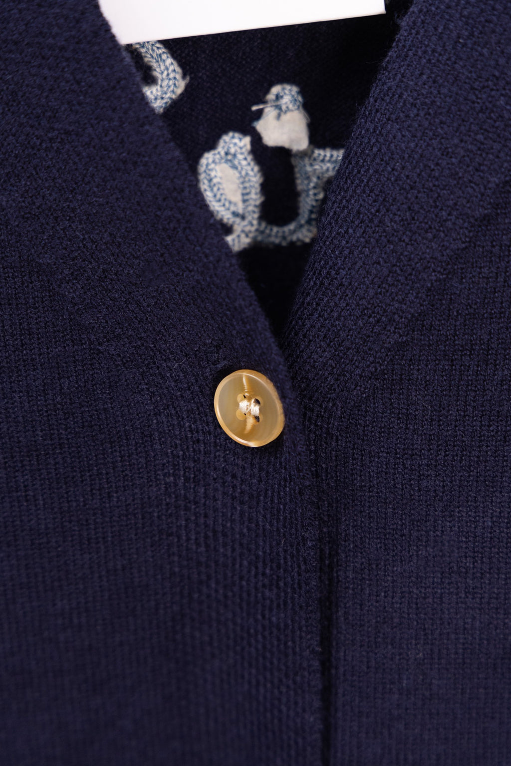 Navy cardigan with gold front button and patterned inner trim