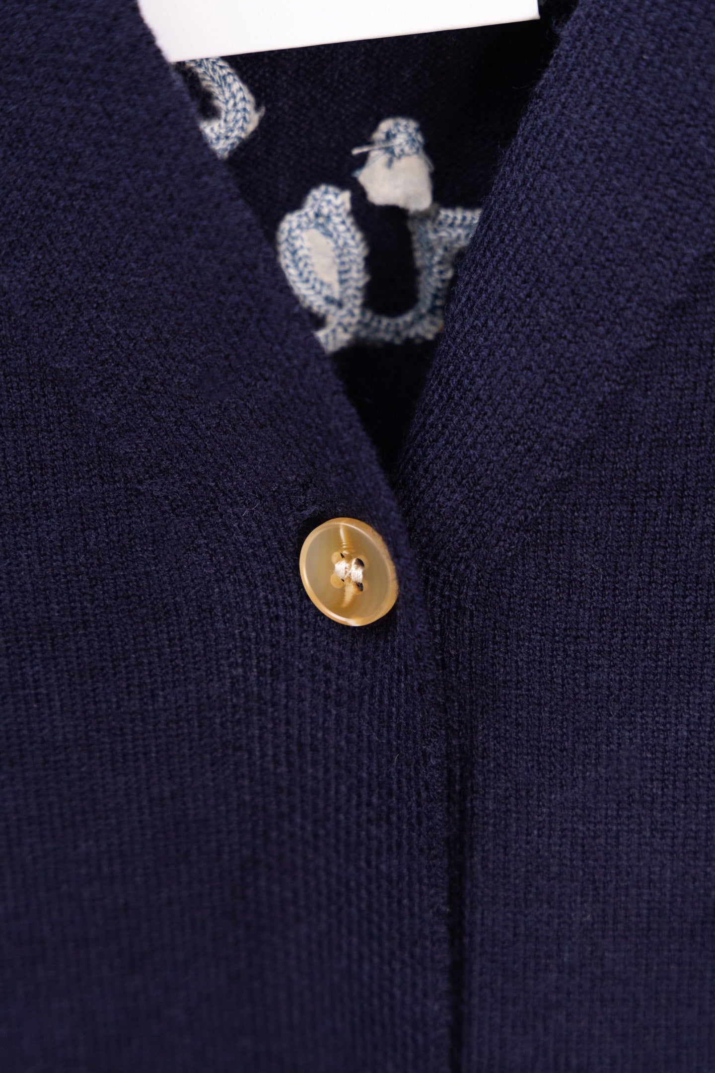 Navy cardigan with gold front button and patterned inner trim