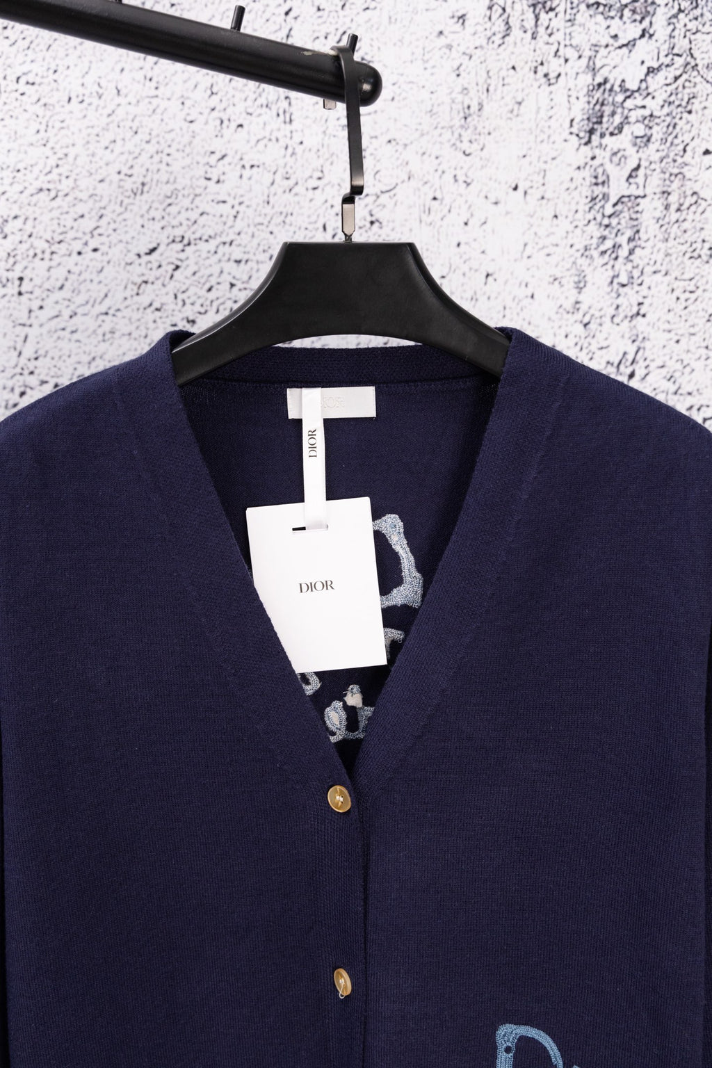 Navy cardigan neckline with blue Dior logo on chest and gold button closure