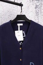 Navy cardigan neckline with blue Dior logo on chest and gold button closure