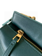 Teal leather bag corner detail with gold zipper pull and stitched trim