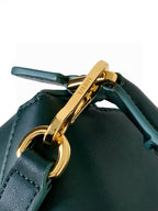 Teal leather bag with gold-tone clasp and front ring hardware, close-up