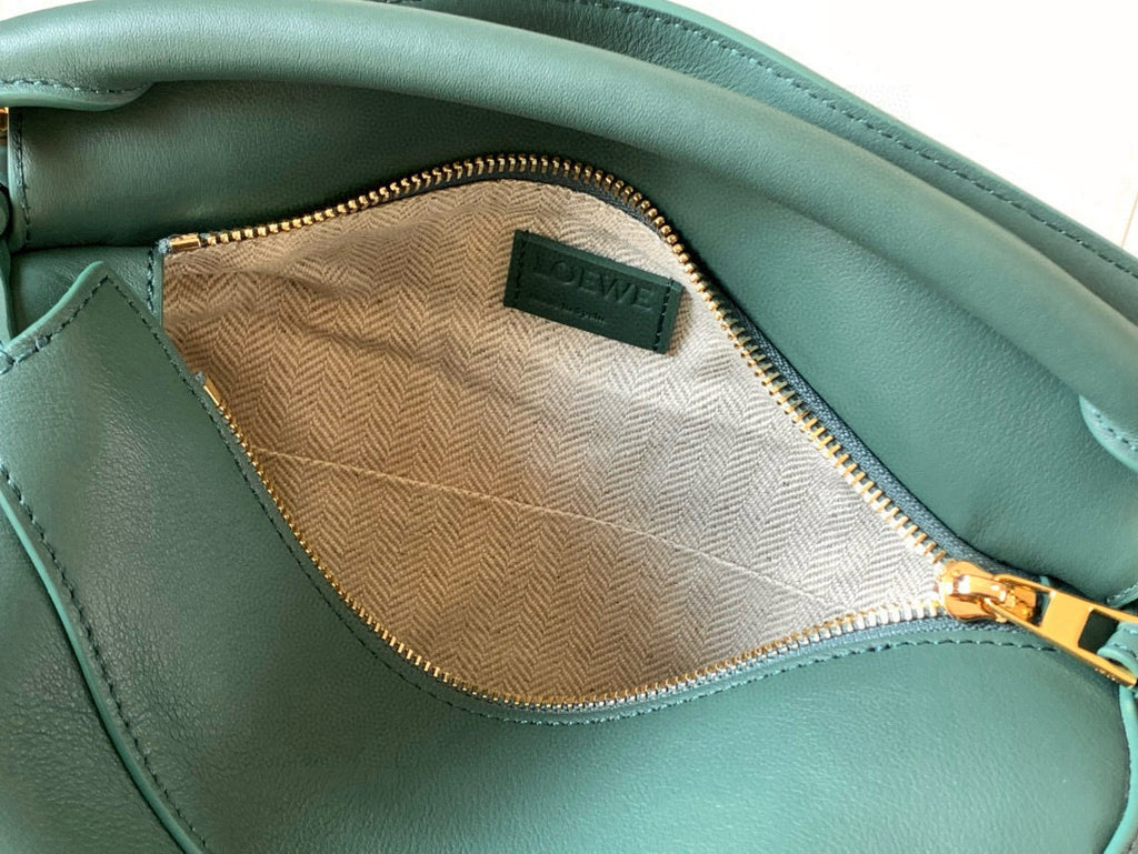 Teal leather bag interior with tan fabric lining and zippered pocket