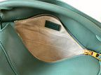 Teal leather bag interior with tan fabric lining and zippered pocket