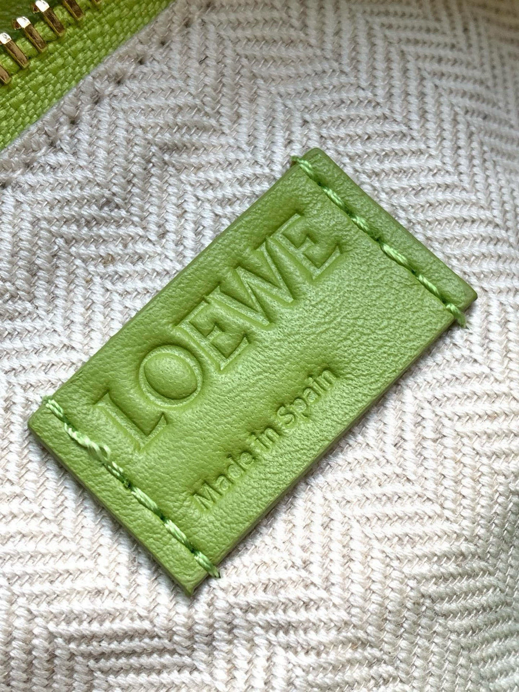 Loewe men’s lime-green leather logo tag on gray herringbone lining