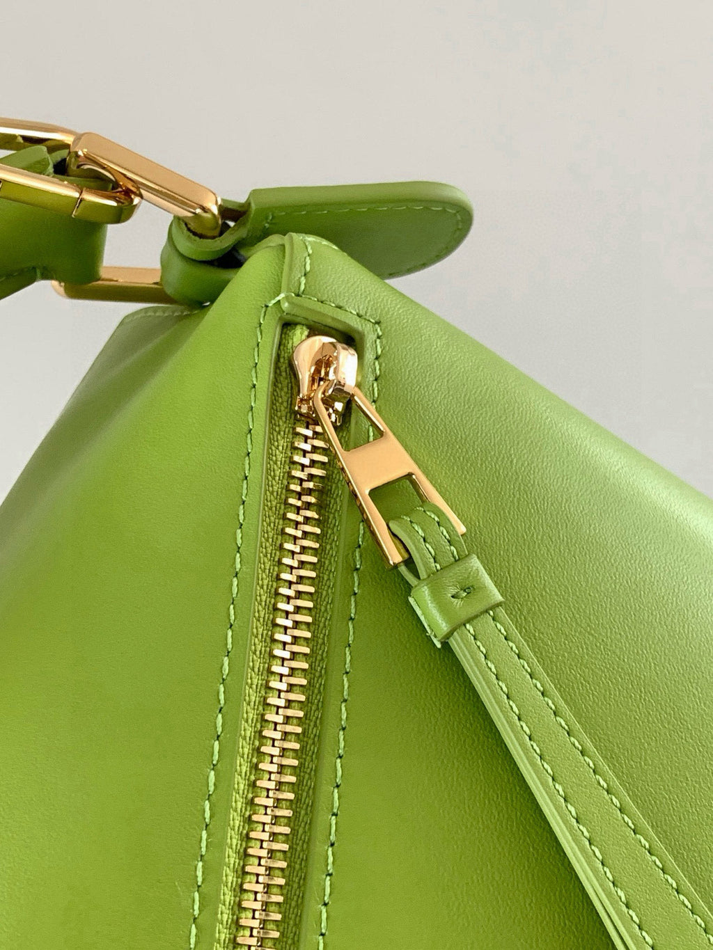 Loewe men’s lime-green leather bag detail with zipper pull and gold-tone hardware