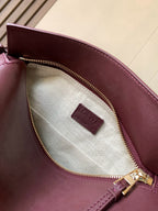 Loewe burgundy leather bag interior with striped lining and gold zip closure