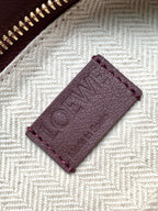 Close-up of burgundy leather Loewe logo patch inside the bag lining