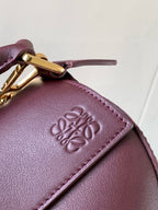 Loewe burgundy leather bag front with embossed logo and stitched edge