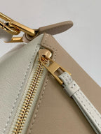 Loewe bag close-up: gold zipper pull with stitched leather strap and rivet