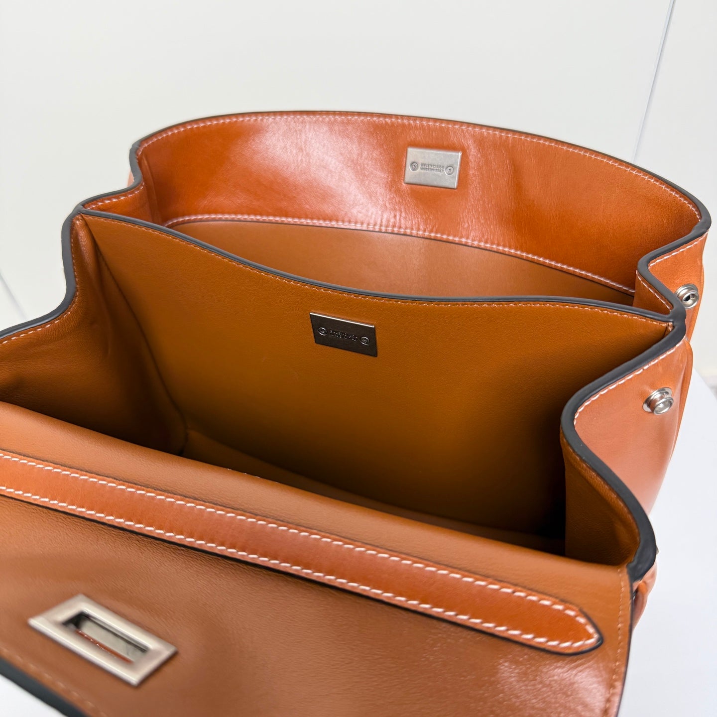 Balenciaga leather bag interior with lined pocket, small logo label, and side snap rivet