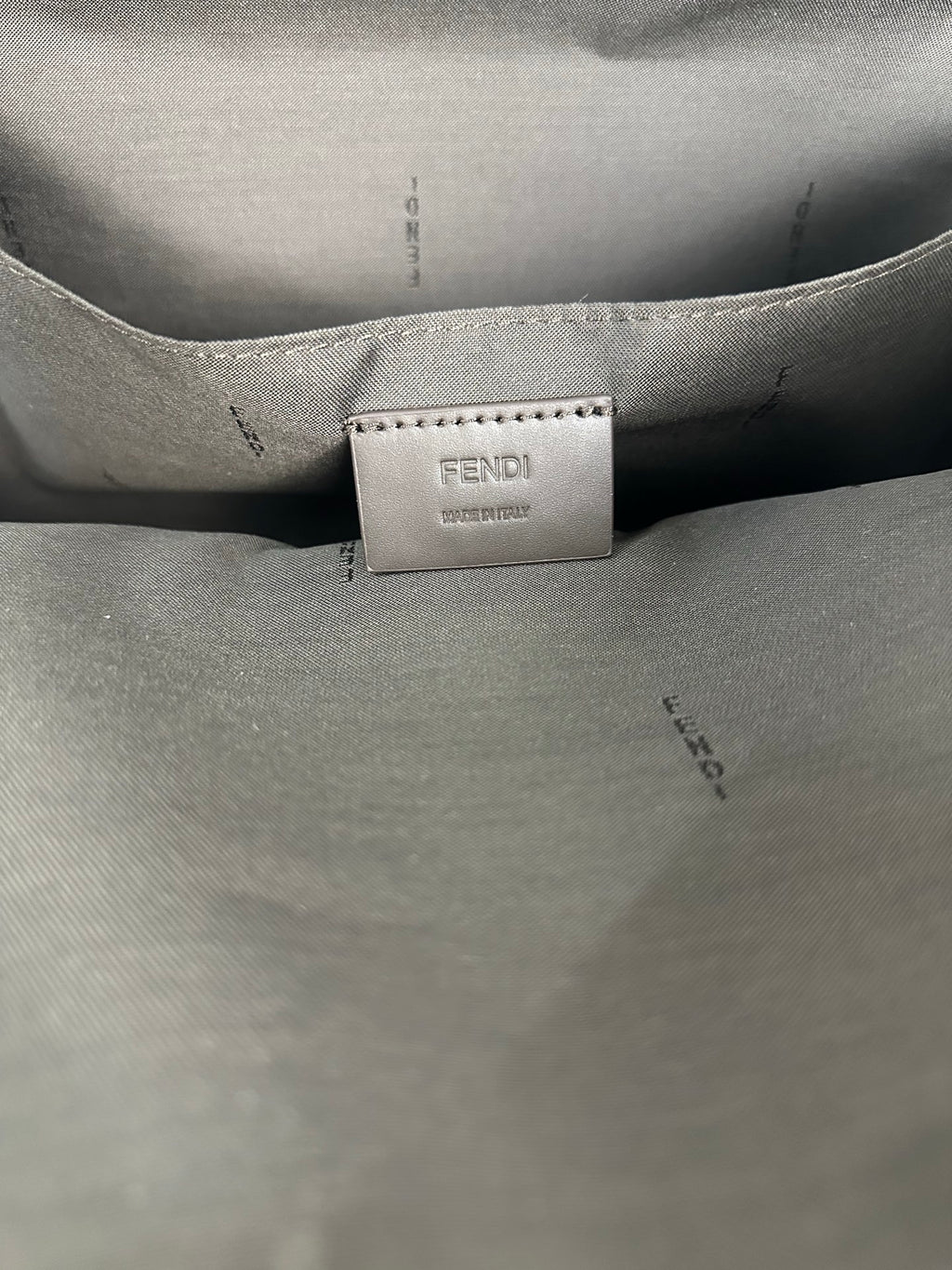 Fendi bag interior care label on light lining near small logo patch