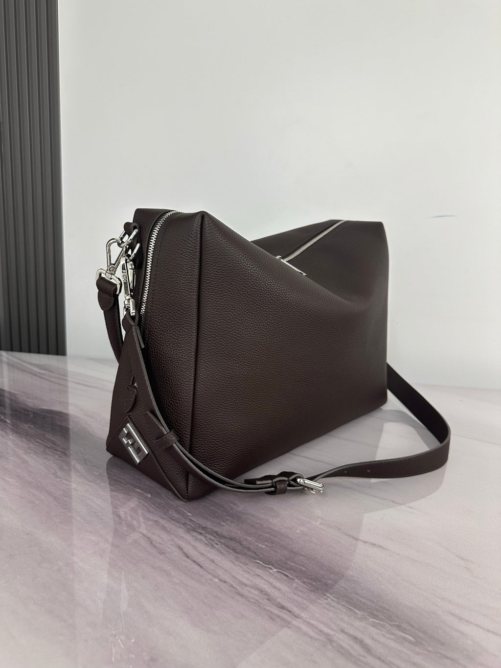 Fendi shoulder bag in dark brown with textured finish, side view, and crossbody strap