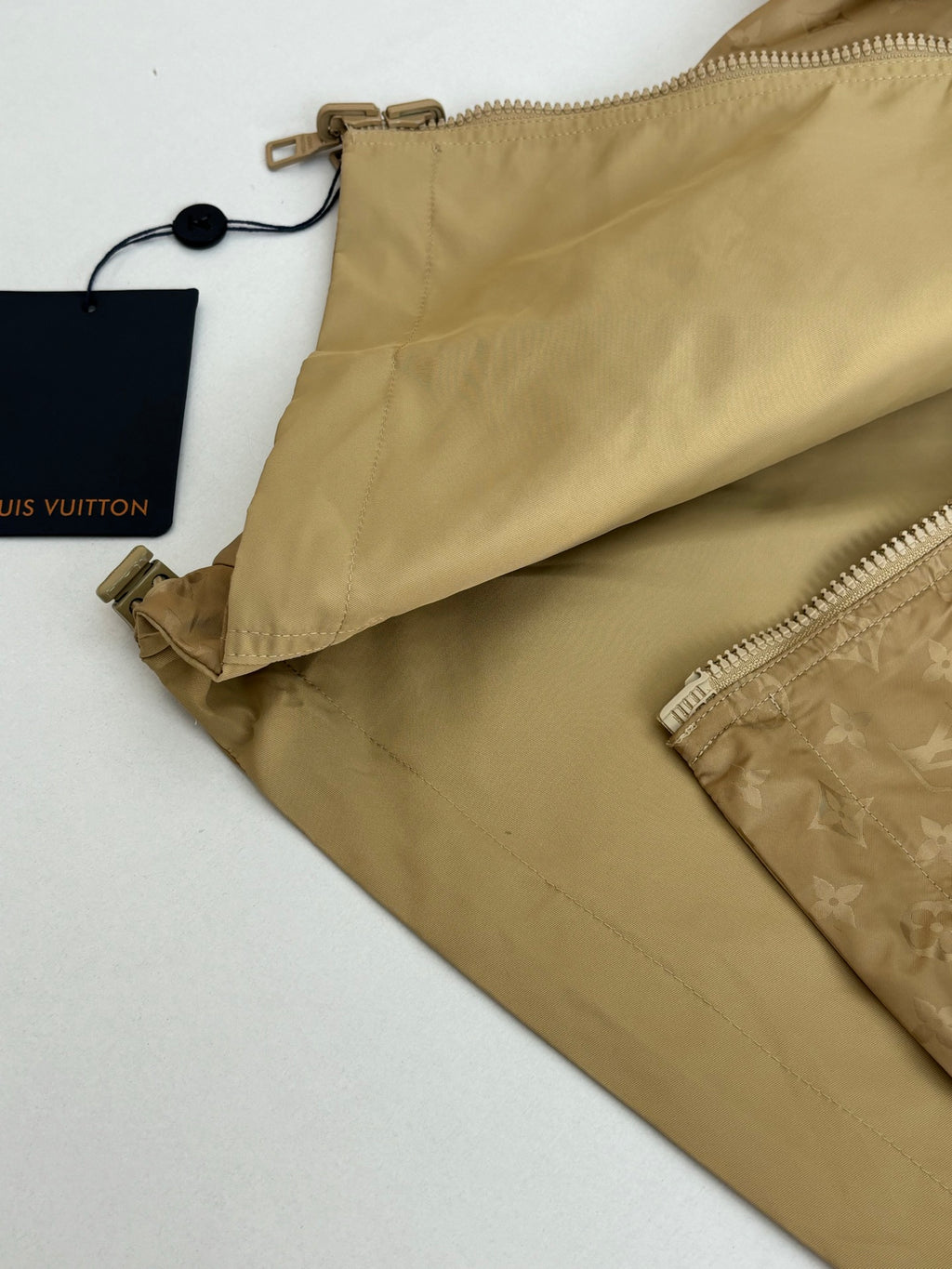 Beige long pants with zipper and logo patch inside pocket